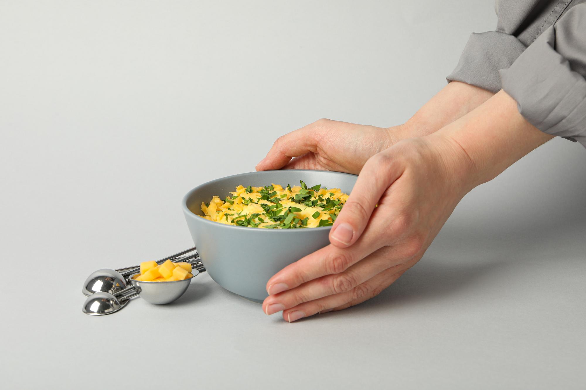 Hands garnishing a bowl